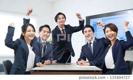 一群商務人士在辦公室揮舞著拳頭 一群商務人士在辦公室揮舞著拳頭 135804727