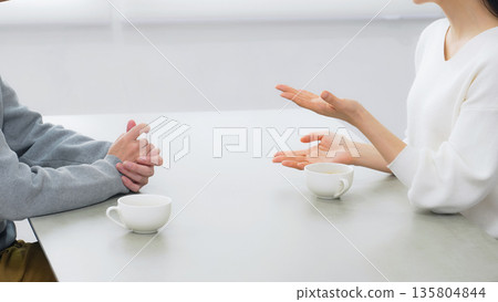 A male and female couple talking in a room 135804844