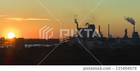 Large factory structure with smoke from production process risin 135804878