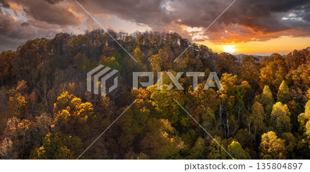 Appalachian mountain hills on autumn evening with brightly illuminated lush and pine woods at fall season. Autumnal landscape of beautiful nature Appalachian mountain hills on autumn evening with brightly illuminated lush and pine woods at fall season. Autumnal landscape of beautiful nature 135804897