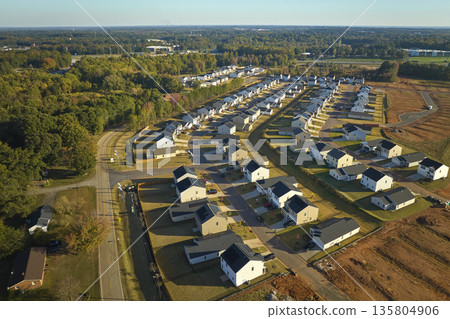 Aerial view of tightly packed homes in South Carolina residential area. New family houses as example of real estate development in american suburbs Aerial view of tightly packed homes in South Carolina residential area. New family houses as example of real estate development in american suburbs 135804906
