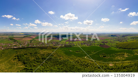 Aerial landscape view of green cultivated agricultural fields with growing crops on bright summer day 135804919