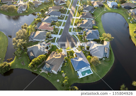 Aerial evening view of spacious family houses in Florida suburban area. Real estate development in American suburbs Aerial evening view of spacious family houses in Florida suburban area. Real estate development in American suburbs 135804926