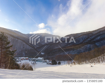 從山腰向下望去，可以看到雪地公園尾瀨戶倉的建築群和冬季的日落（群馬縣片科村） 135805180