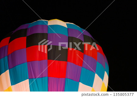 colorful hot air balloons glowing against dark night sky 135805377