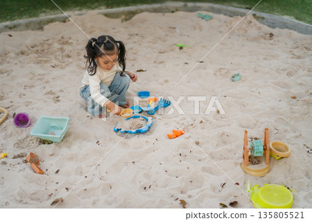 happy child girl playing sand with toy on playground 135805521