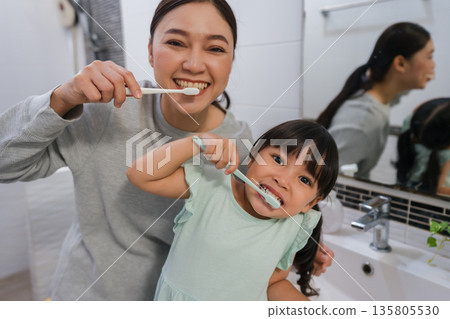 mother teaching girl child to brushing teeth in bathroom mother teaching girl child to brushing teeth in bathroom 135805530