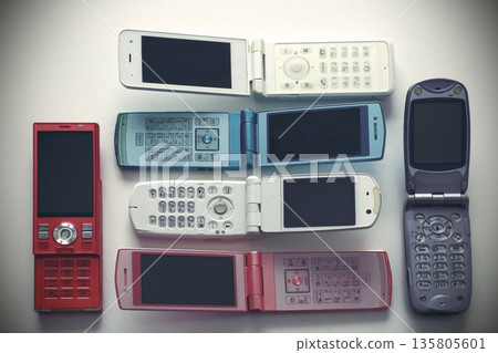 An old-fashioned flip phone placed on a white background 135805601