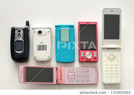 An old-fashioned flip phone placed on a white background 135805602