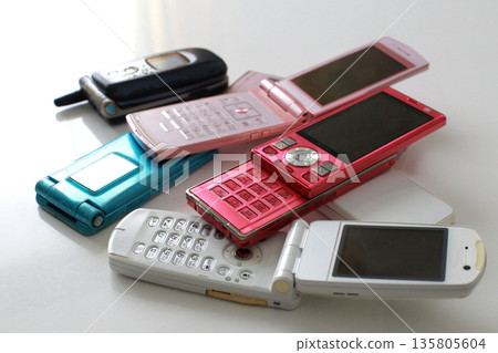 An old-fashioned flip phone placed on a white background 135805604