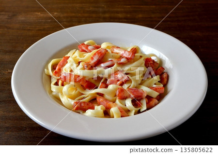 餐桌背景上的義大利寬麵配培根蛋麵 餐桌背景上的義大利寬麵配培根蛋麵 135805622