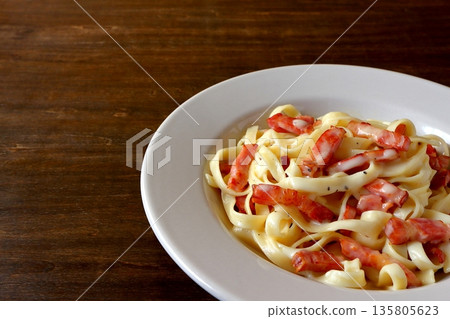 餐桌背景上的義大利寬麵配培根蛋麵 餐桌背景上的義大利寬麵配培根蛋麵 135805623