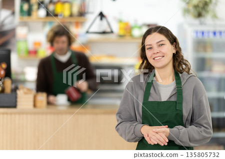 Female cafe employee carries coffee in cozy cafe Female cafe employee carries coffee in cozy cafe 135805732