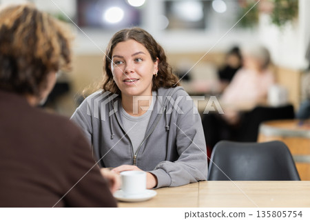 Girl in cafe sits near guy companion, work or romantic meeting dating 135805754