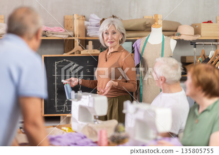Female instructor explaining garment construction at blackboard during sewing class 135805755