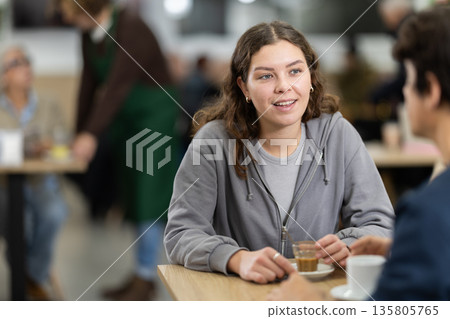 Girl in cafe sits near guy companion, work or romantic meeting dating Girl in cafe sits near guy companion, work or romantic meeting dating 135805765