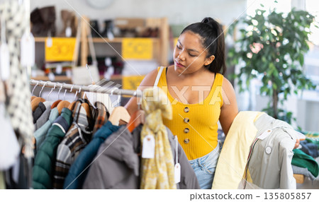 Girl at trading floor pick out and buying down jacket 135805857