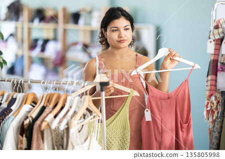 Girl at trading floor pick out and buying sundress or tank top 135805998