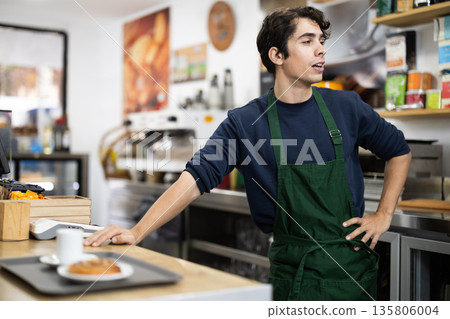 Barista guy standing near counters with food tray Barista guy standing near counters with food tray 135806004