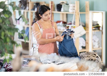 Latina chooses jeans in a clothing store 135806069