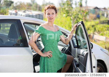 Adult woman posing by car in garden 135806071