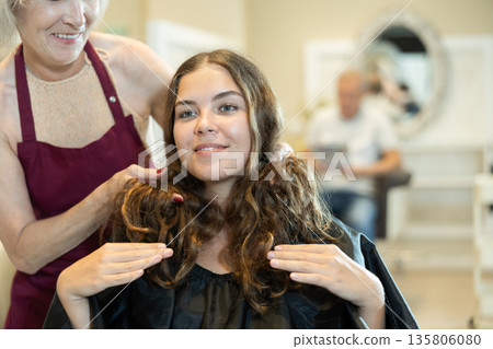 Experienced woman hairdresser discussing hairstyling with young female client Experienced woman hairdresser discussing hairstyling with young female client 135806080