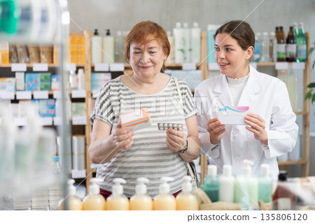 Woman choosing pills with help from pharmacist Woman choosing pills with help from pharmacist 135806120