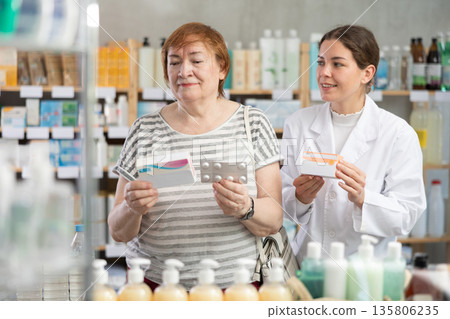 mature woman chooses paracetamol and consults a pharmacist mature woman chooses paracetamol and consults a pharmacist 135806235
