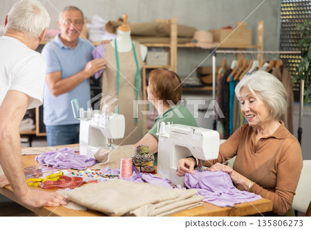 Elderly male teacher showing how to sew on mannequin Elderly male teacher showing how to sew on mannequin 135806273