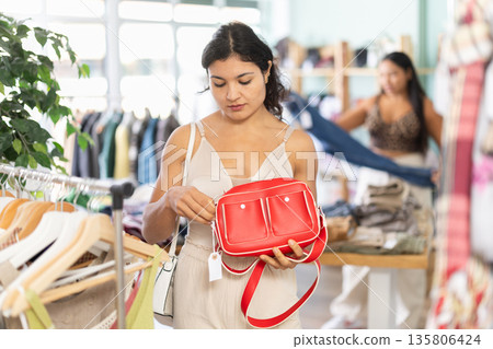 Young women choosing handbag in store Young women choosing handbag in store 135806424