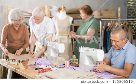 Group of senior learners enjoying sewing class in workshop 135806516