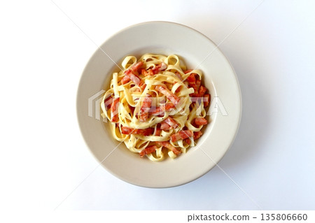 Top view of tagliatelle carbonara with plenty of bacon on a white background Top view of tagliatelle carbonara with plenty of bacon on a white background 135806660