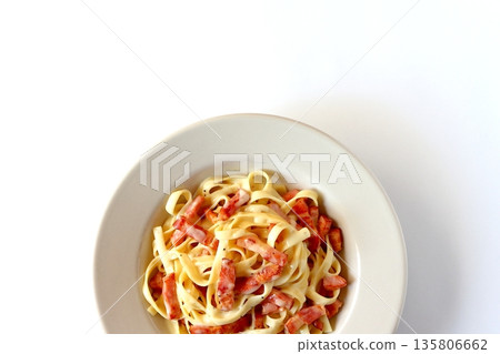 Top view of tagliatelle carbonara with plenty of bacon on a white background Top view of tagliatelle carbonara with plenty of bacon on a white background 135806662