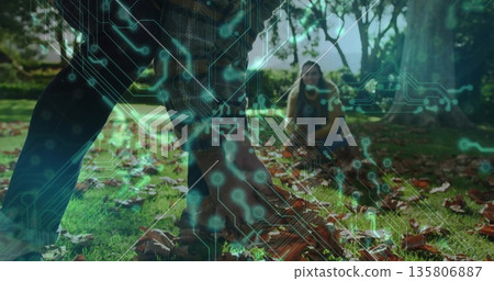 Picking couple collecting fallen leaves in public park, with green circuit board overlay Picking couple collecting fallen leaves in public park, with green circuit board overlay 135806887