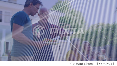Serving vegetable platter mature man wearing blue t-shirt at patio table in backyard, copy space 135806951
