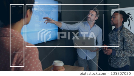 Senior presenter in blue shirt holding laptop presenting data on world map screen at meeting room 135807020