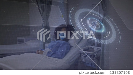 Lying patient wearing gown and mask viewing holographic data in hospital ward, IV stand, copy space Lying patient wearing gown and mask viewing holographic data in hospital ward, IV stand, copy space 135807108