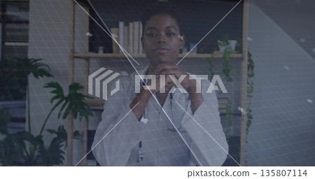 Sitting doctor wearing white coat and stethoscope at clinic desk, under grid overlay with plants Sitting doctor wearing white coat and stethoscope at clinic desk, under grid overlay with plants 135807114