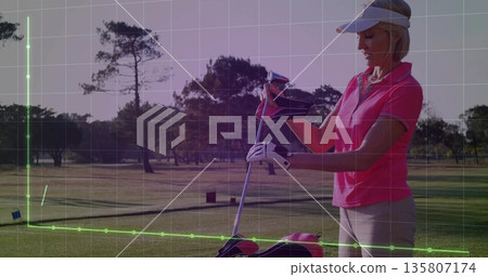 Woman pulling headcover over golf club on golf course, wearing polo, with golf bag, copy space Woman pulling headcover over golf club on golf course, wearing polo, with golf bag, copy space 135807174