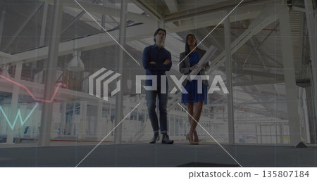 Surveying professionals in business attire inspecting mezzanine walkway, with rolled plans Surveying professionals in business attire inspecting mezzanine walkway, with rolled plans 135807184