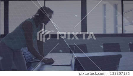 Leaning woman focusing on laptop in conference room, with long table and windows copy space Leaning woman focusing on laptop in conference room, with long table and windows copy space 135807185