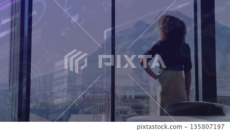 Standing businesswoman viewing city skyline via windows in office with data overlay, copy space Standing businesswoman viewing city skyline via windows in office with data overlay, copy space 135807197