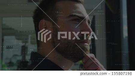Gazing man wearing business attire resting hand on chin at office window, with binary code overlay Gazing man wearing business attire resting hand on chin at office window, with binary code overlay 135807198
