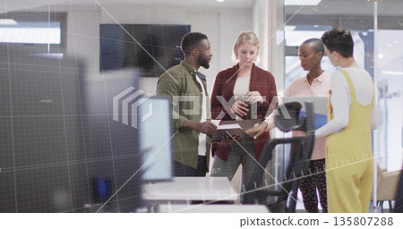 Discussing colleagues reviewing folder by monitors in modern office, with glass walls Discussing colleagues reviewing folder by monitors in modern office, with glass walls 135807288