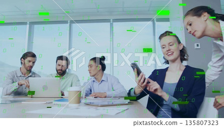 Discussing team wearing suits pointing at laptop and tapping smartphone in boardroom 135807323