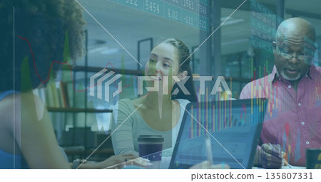 Collaborating professionals analyzing financial charts around table in meeting room, with laptop Collaborating professionals analyzing financial charts around table in meeting room, with laptop 135807331