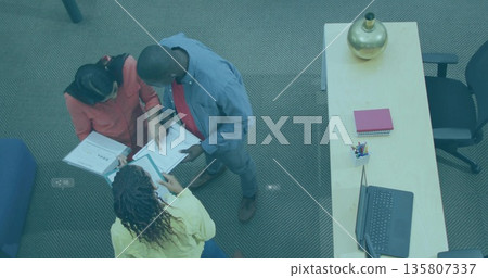 Collaborating colleagues leaning over documents on carpeted floor, laptop and binders, copy space Collaborating colleagues leaning over documents on carpeted floor, laptop and binders, copy space 135807337