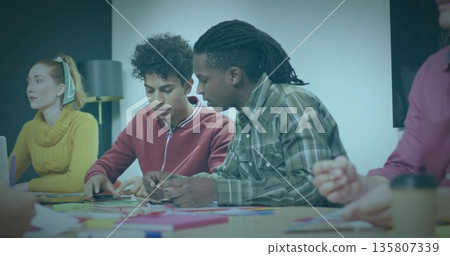 Collaborating team arranging colored paper and sticky notes in meeting room, design exercise Collaborating team arranging colored paper and sticky notes in meeting room, design exercise 135807339