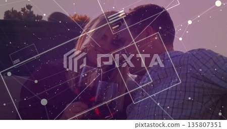 Couple leaning heads holding red wine glasses on rooftop, with succulents under digital overlay 135807351
