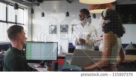 Presenting project on laptop by collaborating woman at open office, with world map graphic overlay 135807370